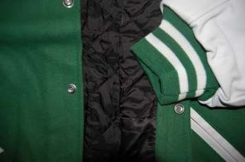 A green varsity jacket with knitted striped cuffs and snap buttons